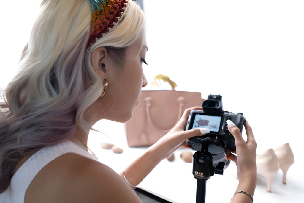A photographer adjusting a camera while preparing for product photography.