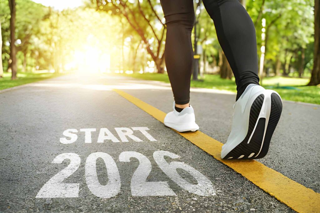 Lifestyle shot of a model jogging in nature during the morning, showcasing running shoes and a fitness tracker.