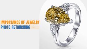 A silver ring with a large teardrop-shaped yellow gemstone and two smaller diamonds is displayed. The text reads, "Importance of Jewelry Photo Retouching".