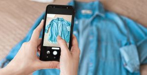 Clothing photography ideas: a person taking a picture of a blue shirt using a mobile phone.