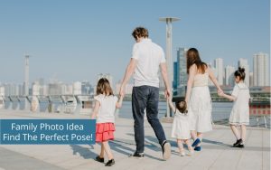 Family holding hands and walking by a river with a city skyline in the background, presenting family photography ideas.