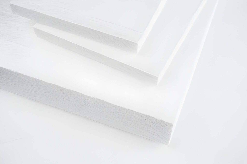 Close-up of three stacked white foam boards on a white surface. The clean, minimalistic composition conveys a sense of simplicity and purity.