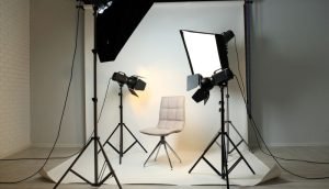 A photo studio featuring professional lighting equipment and a stylish chair, ready for white background product photography.