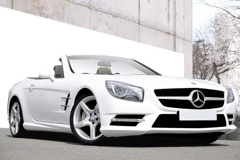 A Mercedes SLK 55 AMG convertible gleaming under the sunlight after professional photo retouching, showcasing its sleek lines and vibrant color.