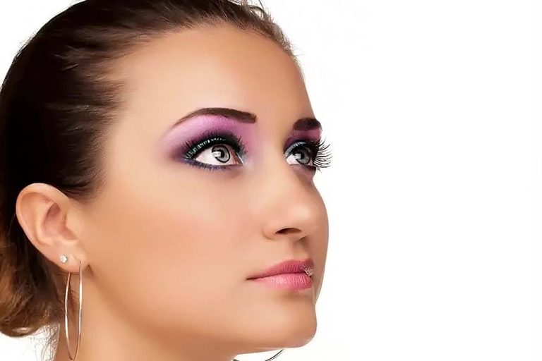 after high end retouching: A woman with vibrant purple and pink makeup, showcasing a bold and colorful look.