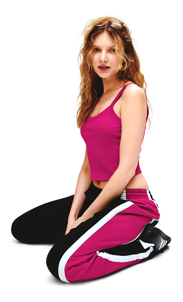 We edited a women photo with long hair wearing a pink tank top and pink and black athletic pants with white stripes, kneeling on one knee.