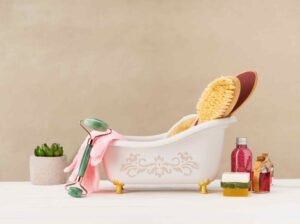 Several shower product like, shower gel, soap and other shower accessories are grounded in front of a bath tub. Spa accessories, a little plant and a pink towel are used as props strategically. 