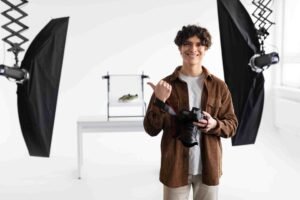 a man holding a camera in front of a product photography lighting setup