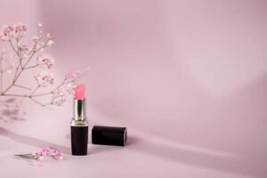 Pink lipstick and flowers on a pastel background.