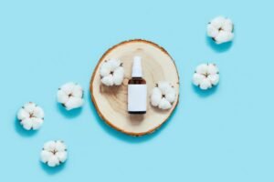 Cotton flowers and buds displayed against a serene blue background, highlighting their natural beauty and delicate texture as flat lay product photography.