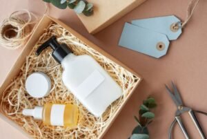 A collection of cosmetic products neatly arranged in a box, set against a warm brown background.