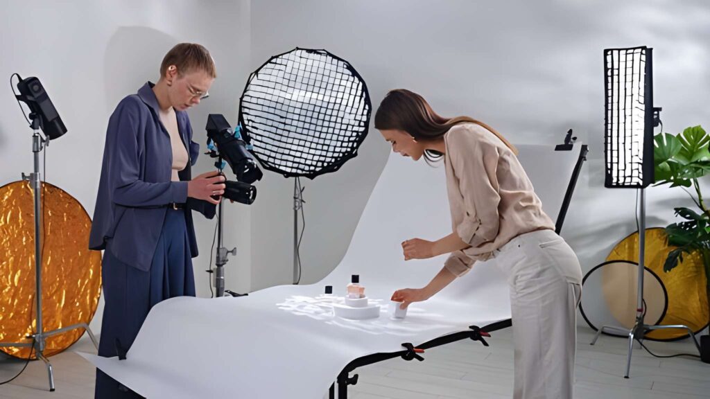 A photographer and assistant setting up lighting for a makeup product photo shoot.