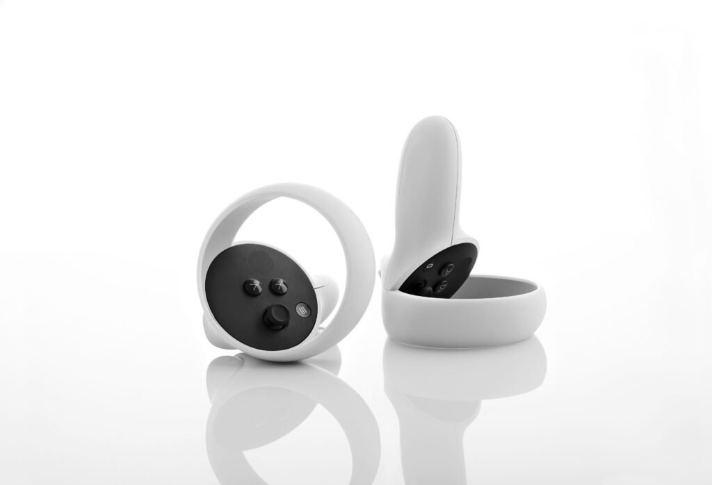 Two white wireless earphones with a sleek design on a reflective surface.