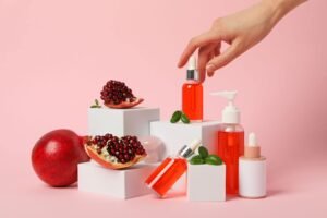 A hand selecting a pomegranate from white boxes filled with various cosmetics, showcasing a props for product photography as blend of beauty and nature.