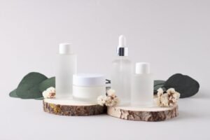 Three bottles of cosmetic products elegantly arranged on a wooden block, showcasing their sleek designs and labels.