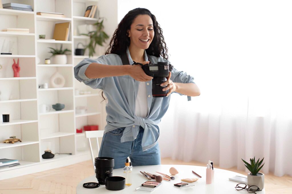 Cheerful professional photographer lady taking-photos of makeup products indoor