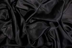 Elegant black satin fabric with smooth texture and gentle folds.