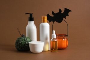 1. Halloween-themed cosmetics arranged on a brown background, showcasing vibrant colors and spooky designs for festive cosmetic products.