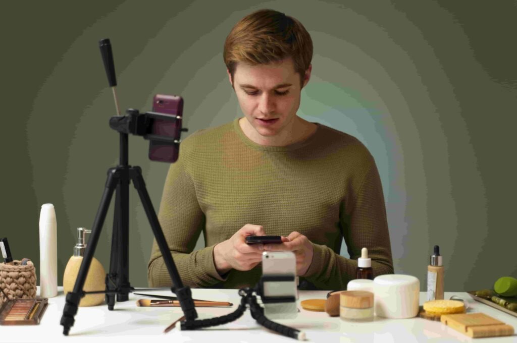 A man using mobile in front of a tripod