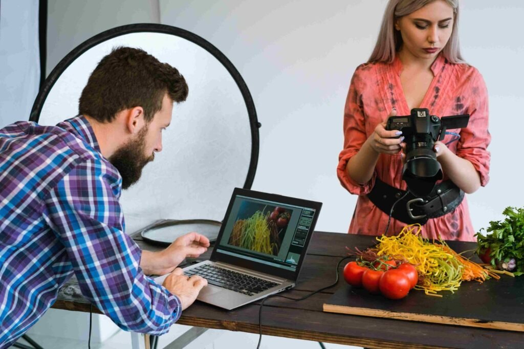 an woman capturing picture of a product and a man using  laptop