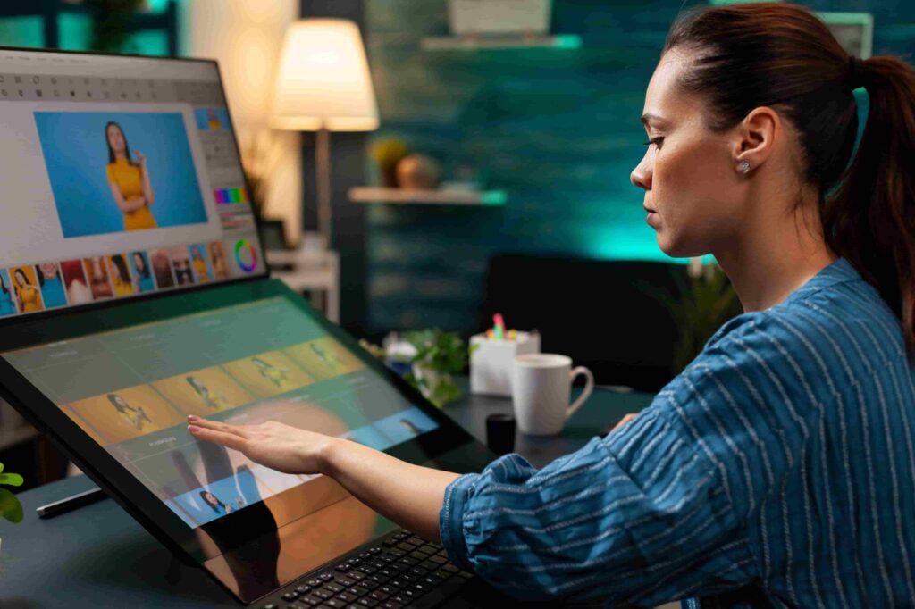 Person editing photos on large touchscreen in modern workspace, highlighting common photo editing mistakes to avoid.