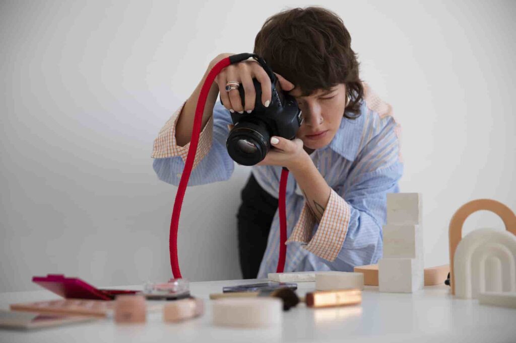 Photographer capturing beauty products and minimalist sculptures in a creative workspace to create sellable images for photography income.