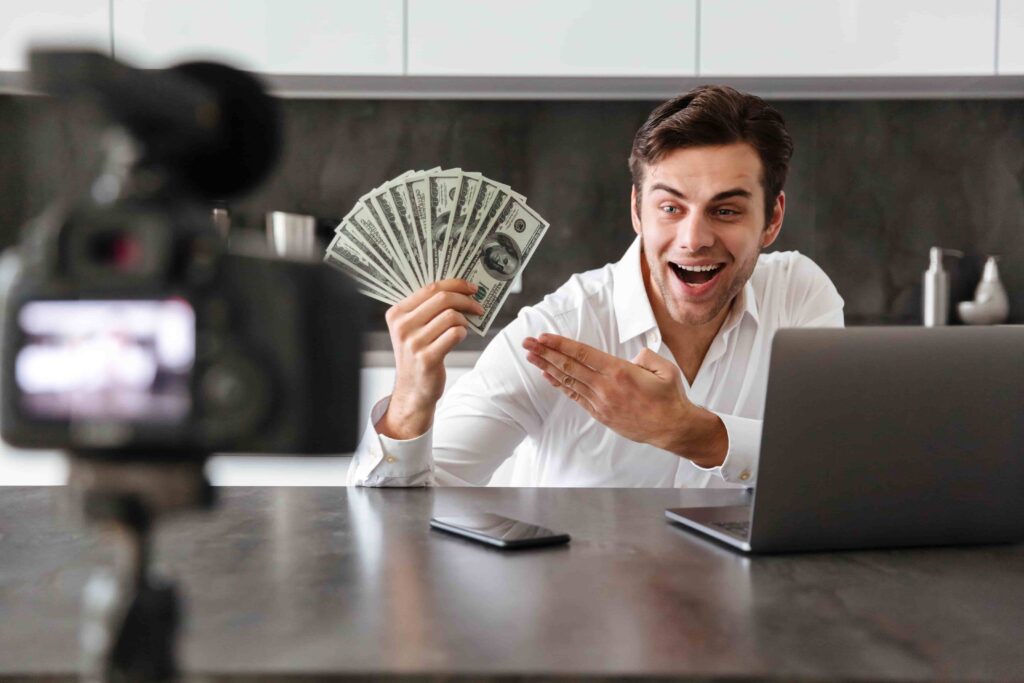 Photographer showing earnings from photography business while recording a video tutorial on making money with photography.