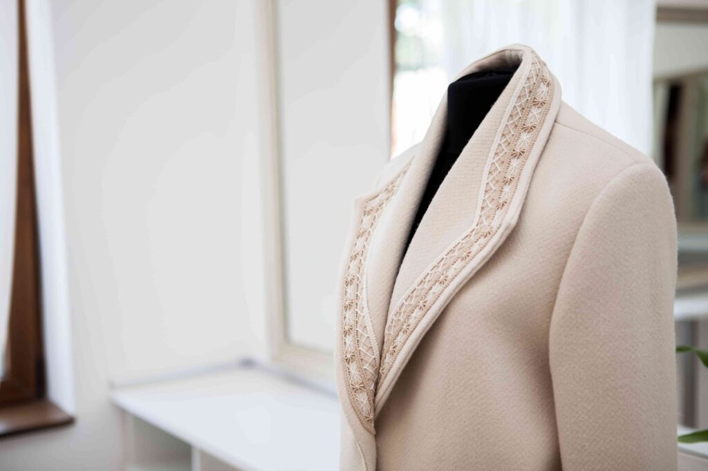 Beige jacket with lace collar showcased using ghost mannequin technique for a clean, professional e-commerce display without visual distractions