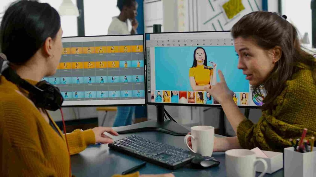 Two woman talking in front of their desk