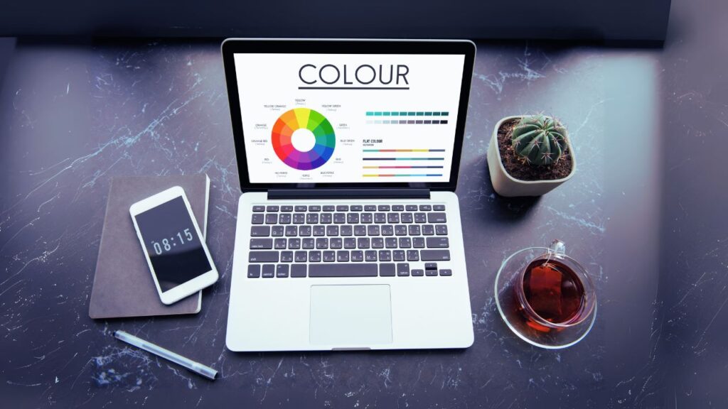 Workspace with a laptop displaying a color wheel—tools like these support color accuracy and editing precision for consistent product photos.