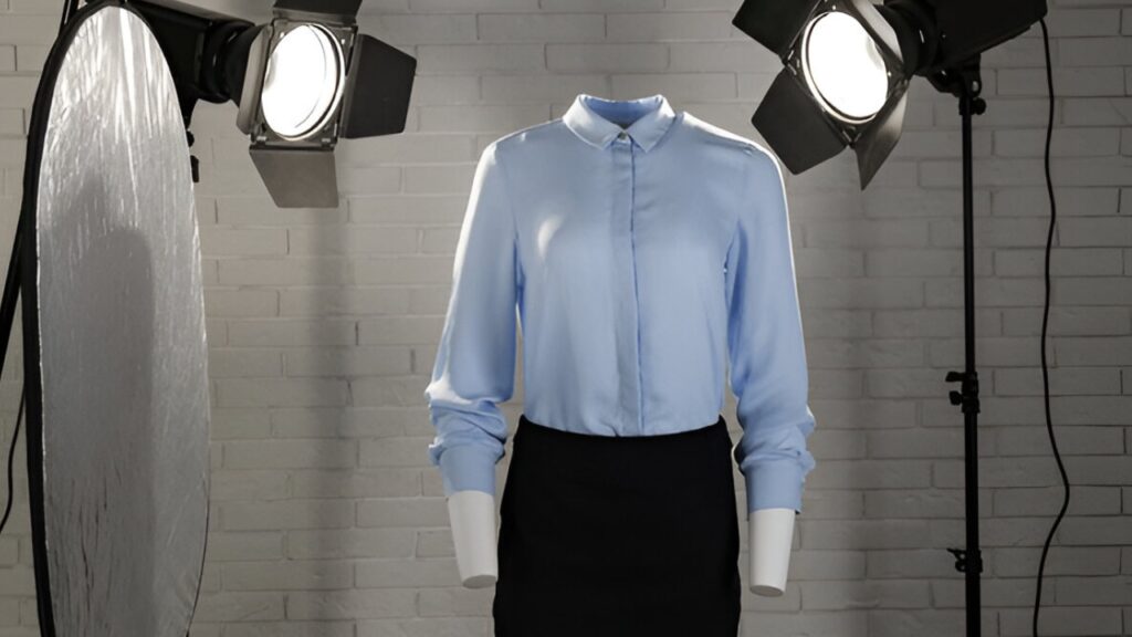 Blue long-sleeve shirt and black skirt displayed using invisible ghost mannequin photography, highlighted by bright studio lighting against a white brick wall for a crisp apparel showcase.