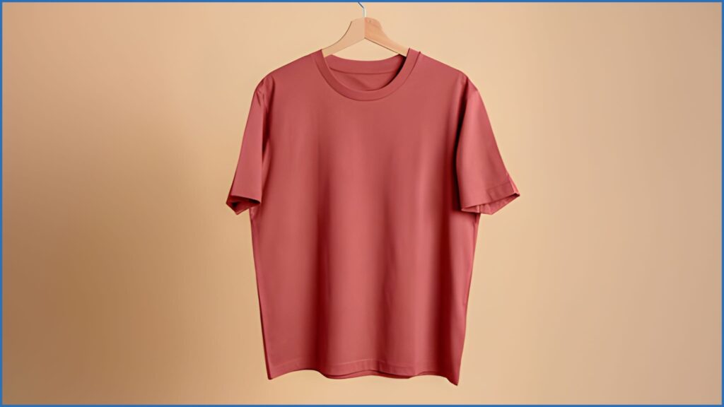 Minimalist product photography of a pink t-shirt hanging on a wooden hanger